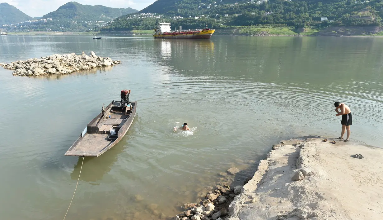 Warga mendinginkan diri di sepanjang Sungai Yangtze, Yunyang, Kotamadya Chongqing, China, 16 Agustus 2022. Suhu tinggi yang tidak biasa dan kekeringan berkepanjangan mempengaruhi sebagian besar wilayah China, mengurangi hasil panen dan persediaan air minum. (Chinatopix Via AP)