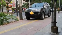 Fortuner hitam ini mengambil hak pejalan kaki dan tuna netra sekaligus, tidak patut dicontoh. (Source: Instagram/@koalisipejalankaki via Instagram/@parkirlobangsat)