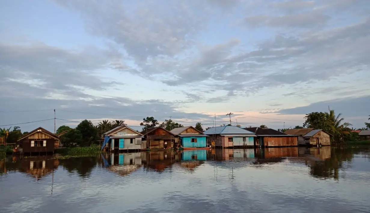 Rumah di pinggir sungai menuju Pasar Terapung Lok Baintan yang indah dengan refleksi (Liputan6.com/Pool/Kadek Arini)