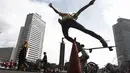 Seorang remaja beraksi dengan skateboard-nya saat hari bebas kendaraan (car free day) di kawasan Bundaran HI Jakarta, Minggu (14/12/2015). (Liputan6.com/Faizal Fanani)