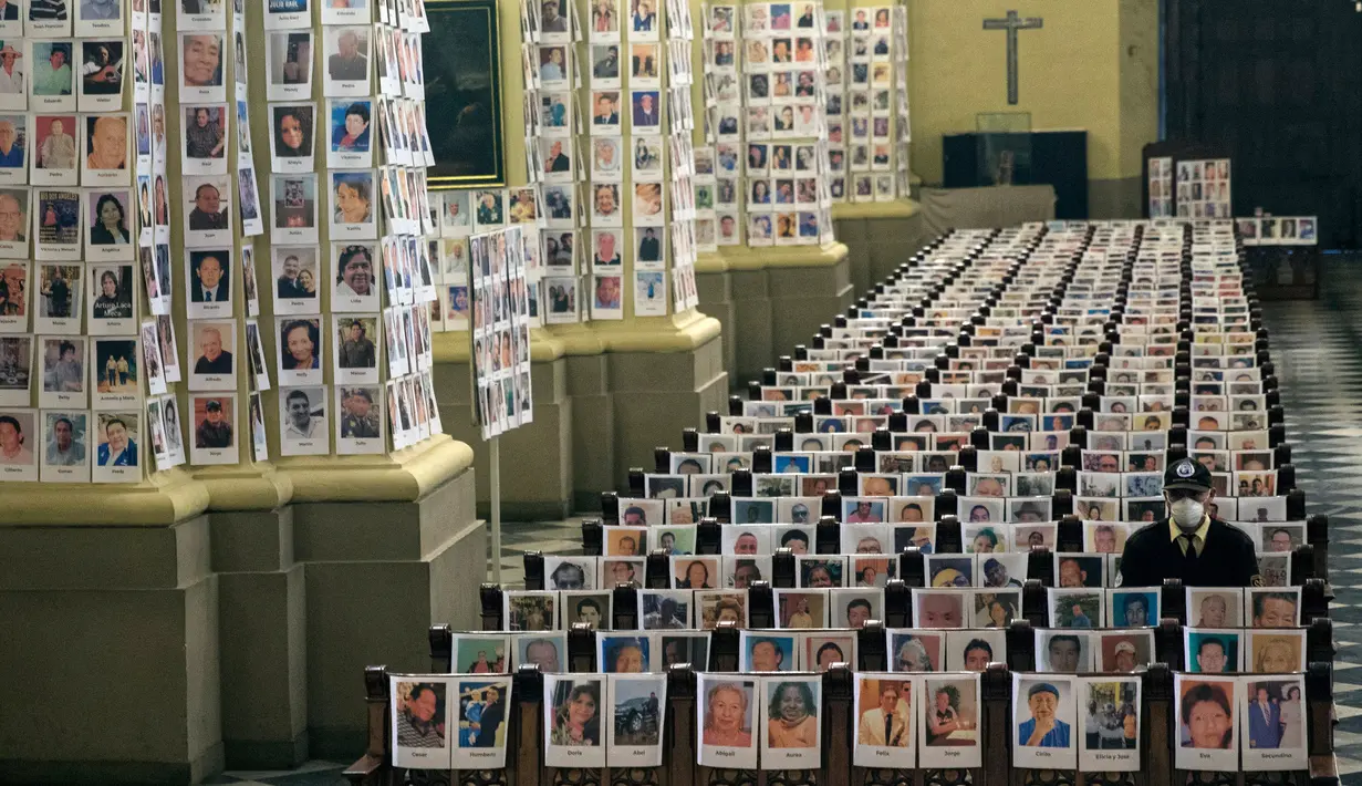 Petugas keamanan duduk di antara potret korban meninggal akibat virus corona di dalam Katedral, di Lima, Peru pada 13 Juni 2020. Misa Minggu di Katedral Lima dihadiri lebih dari 4.000 potret mereka yang telah meninggal dalam pandemi Covid-19 yang menyebar di Peru. (AP Photo/Rodrigo Abd)