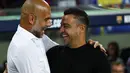 Pelatih Barcelona Xavi Hernandez menyapa manajer Manchester City, Pep Guardiola pada sebuah laga amal di Stadion Camp Nou, Kamis (25/8/2022) dinihari WIB. Laga ini berlangsung menarik karena mempertemukan sang guru dan murid yaitu Pep Guardiola selaku pelatih Man City dan Xavi Hernandes pelatih Barcelona. (AP Photo/Joan Monfort)