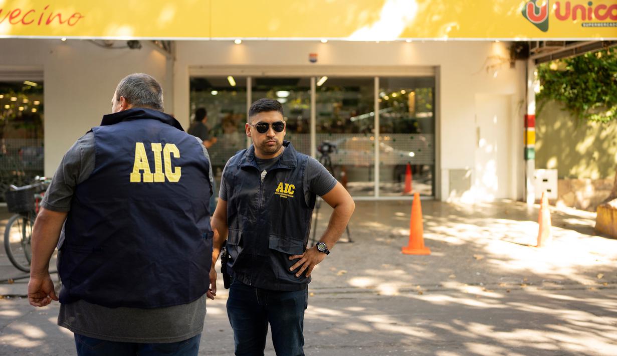 Polisi berkumpul di supermarket Unico, jaringan toko kelontong milik mertua pemain sepak bola Lionel Messi, setelah ditembak di Rosario, Argentina, 2 Maret 2023. "Messi, kami menunggumu, (Pablo) Javkin (wali kota) juga seorang narco (pengedar narkoba), dia tidak akan menjagamu," demikian tulis sang pelaku. (AP Photo/Sebastian Lopez Brach)