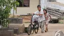 Sony Wakwaw bersama adiknya membawa beberapa barang dengan sepeda saat pindah kerumah barunya di kawasan Cibubur, Jakarta Timur. Foto diambil pada Kamis (4/12/2014). (Liputan6.com/Herman Zakharia)