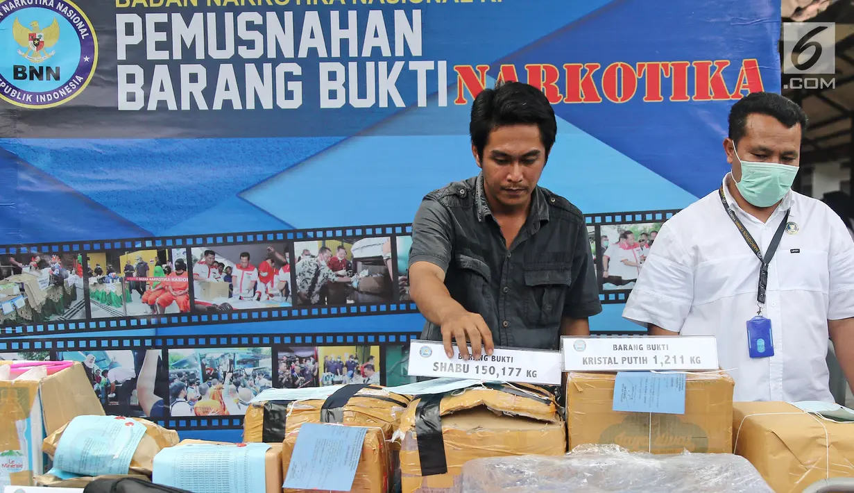 Petugas Badan Narkotika Nasional (BNN) menunjukkan barang bukti narkotika di Lapangan Parkir Gedung BNN, Senin (26/3). Barang bukti tersebut selanjutnya dimusnahkan. (Liputan6.com/Herman Zakharia)