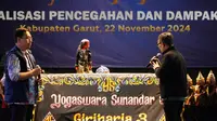 Kementerian Komunikasi dan Digital (Kemkomdigi) RI mengelar Wayang Golek dalam upaya pencegahan bahaya judi online di Lapangan Alun-Alun Cibatu, Kabupaten Garut, Jumat (22/11/2024) malam. (Liputan6.com/Jayadi Supriadin)