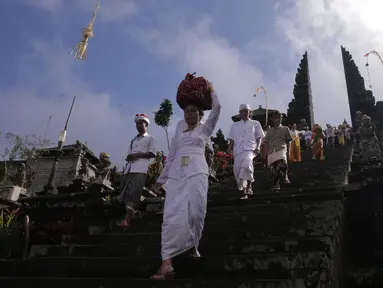 Umat Hindu membawa sesajen dalam prosesi ritual tahunan Purnama Kapat di Pura Besakih, Karangasem, Bali, Kamis (5/10). Ritual tersebut juga dijadikan momentum untuk doa bersama agar bencana gunung meletus tidak terjadi. (Liputan6.com/Gempur M Surya)