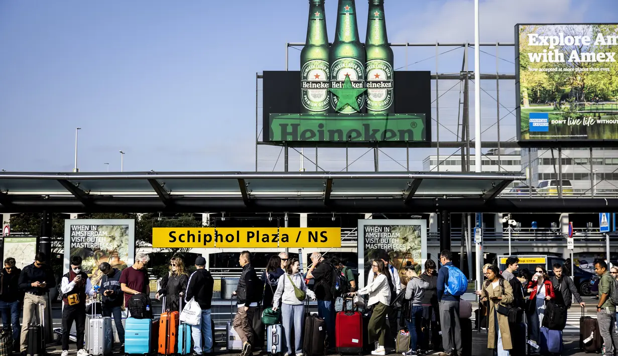 Pelancong yang terlantar menunggu taksi di pangkalan taksi resmi di Bandara Schiphol Amsterdam setelah lalu lintas kereta api dihentikan, pada 5 Juni 2023. (AFP/ANP/Ramon van Flymen)