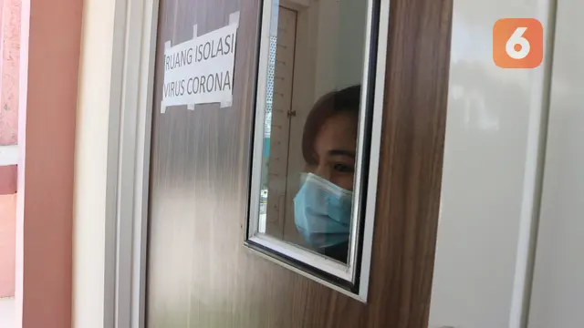 Seorang perawat mengintip dari jendela ruang isolasi yang disiapkan RSUD Undata Palu untuk pasien virus corona. Foto: Heri Susanto.