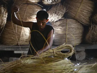 Seorang pekerja menyiapkan rotan untuk diekspor di sebuah bengkel di Banda Aceh (16/10/2019). Aceh merupakan salah satu sentra produksi rotan terbesar di Sumatera. (AFP Photo/Chaideer Mahyuddin)