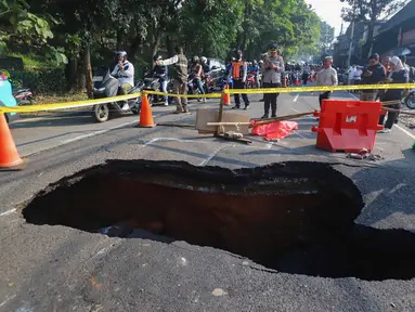 Pengendara melintas di sisi ruas jalan yang ditutup sebagian akibat amblas di Jalan Raya Lenteng Agung, Jakarta Selatan, Jumat (29/5/2026). (merdeka.com/Arie Basuki)