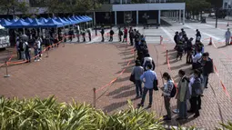 Orang-orang berdiri dalam antrean untuk pengujian virus corona COVID-19 di Hong Kong, 12 Februari 2022. Pihak berwenang bergegas untuk meningkatkan kapasitas pengujian COVID-19 menyusul rekor tertinggi infeksi baru. (Louise Delmotte/AFP)