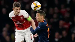 Kapten Arsenal, Laurent Koscielny berebut bola dengan pemain Valencia, Rodrigo dalam leg pertama semifinal Liga Europa di Emirates Stadium, Jumat (3/5/2019). Sempat tertinggal, Arsenal berhasil mengalahkan tamunya, Valencia dengan skor 3-1. (AP/Kirsty Wigglesworth)