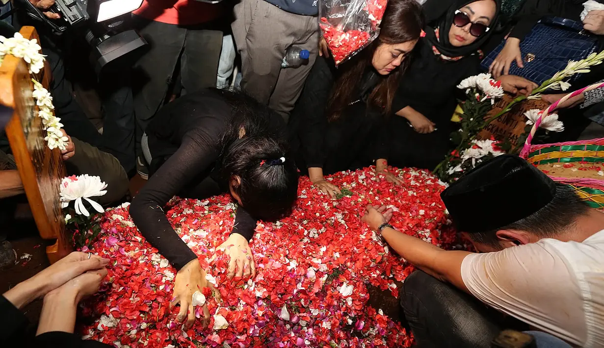 Della yang meluapkan kesedihannya saat itu tidak berhenti menangis. Bahkan ia juga terus memeluk dan  mengais-ngais gundukan tanah merah dan hamparan bunga di atasnya, seakan ingin menggali makam tersebut. (Bambang E.Ros/Bintang.com)