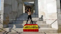 Aktivis perempuan Femen menuliskan "Illegitimate flag" di dadanya dan membawa bendera Spanyol bertuliskan 'Celebrated violence bloody flag' saat unjuk rasa di monumen Konstitusi Spanyol 1978 di Madrid, (11/10). (AFP Photo/Oscar Del Pozo)