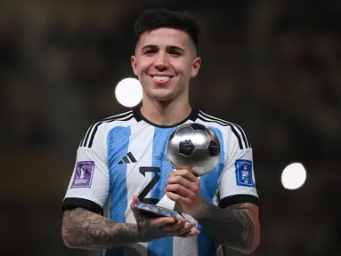 Gelandang Argentina, Enzo Fernandez menerima penghargaan Pemain Muda Terbaik  Dunia pada upacara trofi Piala Dunia Qatar 2022 setelah pertandingan final antara Argentina dan Prancis di Stadion Lusail di Lusail, utara Doha pada 18 Desember 2022.  Chelsea sukses mendaratkan Enzo Fernandez dari Benfica yang merupakan Pemain Muda Terbaik Piala Dunia 2022. (AFP/Franck Fife)