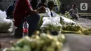 Pedagang musiman melayani pembeli kulit ketupat di bawah kolong jembatan kawasan Pesanggrahan, Jakarta, Jumat (8/7/2022). Kulit ketupat untuk perayaan Idul Adha tersebut dijual dengan harga 10ribu hingga 30ribu rupiah. (Liputan6.com/Johan Tallo)