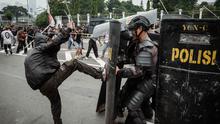 Pengunjuk rasa berusaha menghalangi polisi yang maju dengan perisai selama demonstrasi yang menuntut pembubaran parlemen di depan gedung parlemen Dewan Perwakilan Rakyat di Jakarta pada 25 Agustus 2025. (YASUYOSHI CHIBA/AFP)