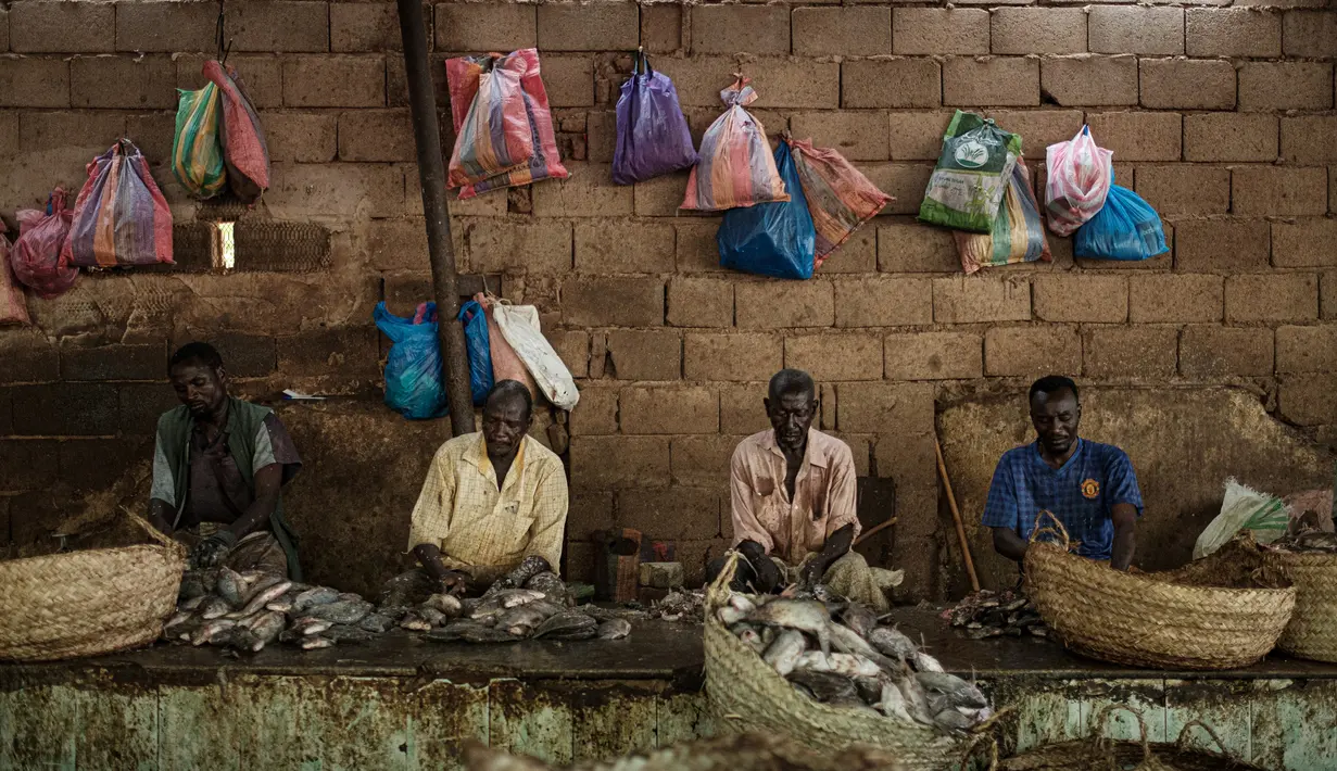 Sejumlah pedagang memotong ikan di sebuah pasar ikan di dekat Sungai Nil, di kota kembar Khartoum, Omdurman (24/6/2019). Khartoum didirikan pada tahun 1821 sebagai pos militer Mesir, namun berkembang menjadi pusat perdagangan regional. (AFP Photo/Yasuyoshi Chiba)