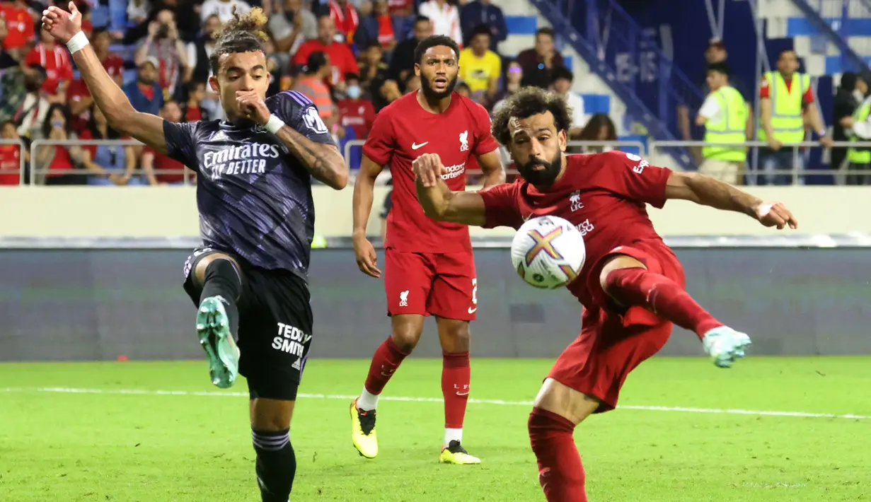 Bek Lyon, Malo Gusto (kiri) mencoba menghalau tendangan penyerang Liverpool, Mohamed Salah pada pertandingan Dubai Super Cup 2022 di Al Maktoum Stadium, Uni Emirat Arab, Minggu (11/12/2022). Lyon menang atas Liverpool 3-1. (AFP/Karim Sahib)
