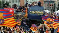 Suporter Barcelona menyambut tim Barcelona yang berpawai dengan menggunakan bus berkeliling kota untuk merayakan gelar La Liga ke-24, Minggu (15/5/2016). (AFP/Pau Barrena)