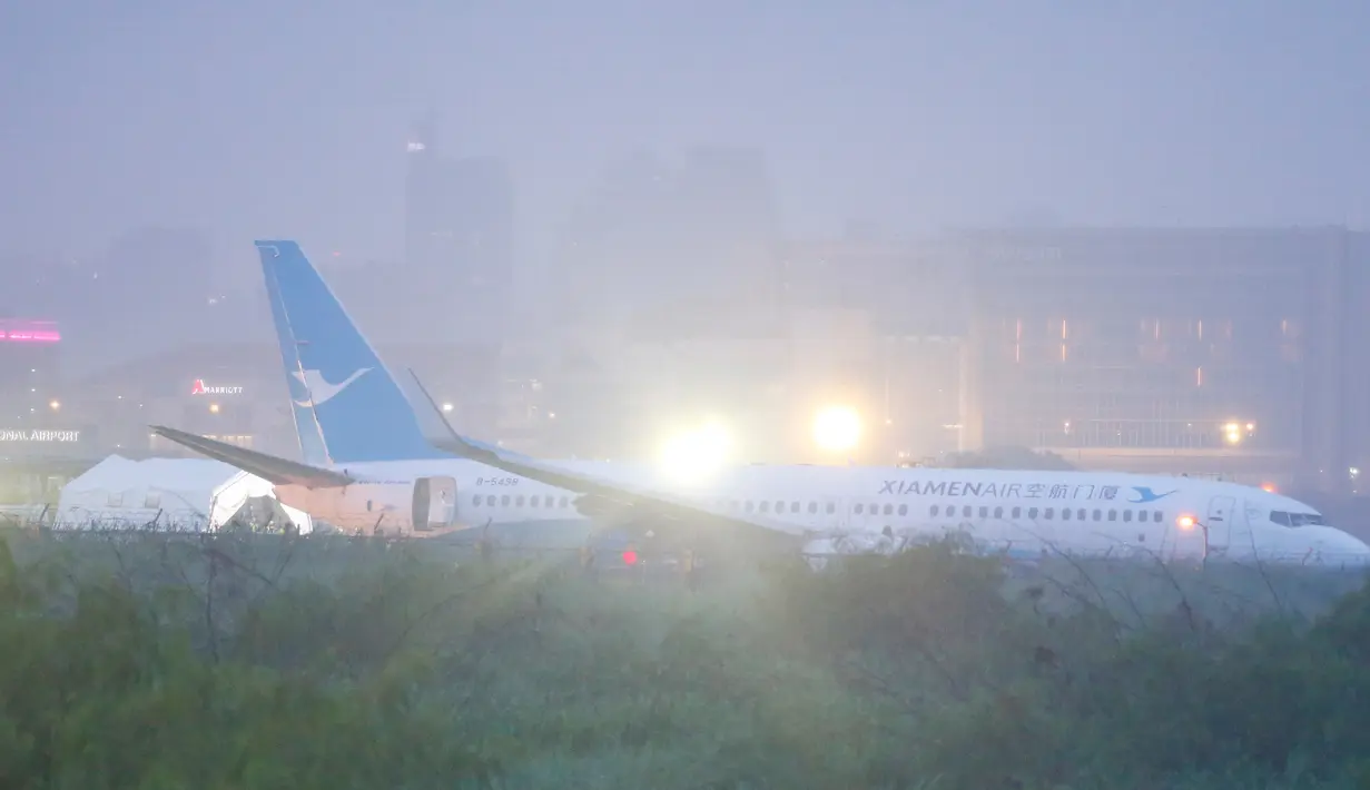 Pesawat milik XiamenAir tergelincir dari landasan saat melakukan pendaratan di bandara internasional Manila, Filipina, Kamis (16/8). Pesawat tersebut berputar-putar di Manila selama sekitar satu jam sebelum mendarat. (AP/Bullit Marquez)