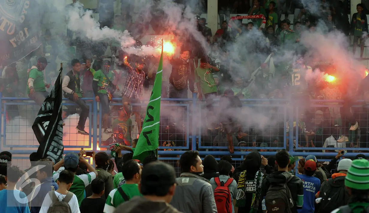 Pendukung Persebaya 1927 atau Bonek menyalakan suar saat aksi di Stadion Tugu, Jakarta, Rabu (3/8). Bonek menyerbu Jakarta sejak Selasa (2/8) untuk mendesak pengakuan klub Persebaya 1927 pada KLB PSSI. (Liputan6.com/Helmi Fithriansyah)