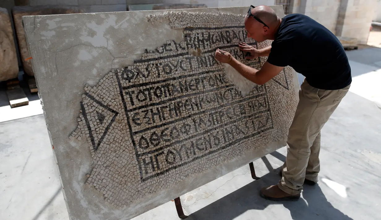 Seorang arkeolog meneliti lantai mosaik berusia 1.500 tahun di Museum Rockefeller, Yerusalem, Rabu (23/8). Penemuan langka tersebut merupakan sebuah peninggalan kuno sekaligus penemuan dokumen bersejarah sekaligus. (AHMAD GHARABLI/AFP)