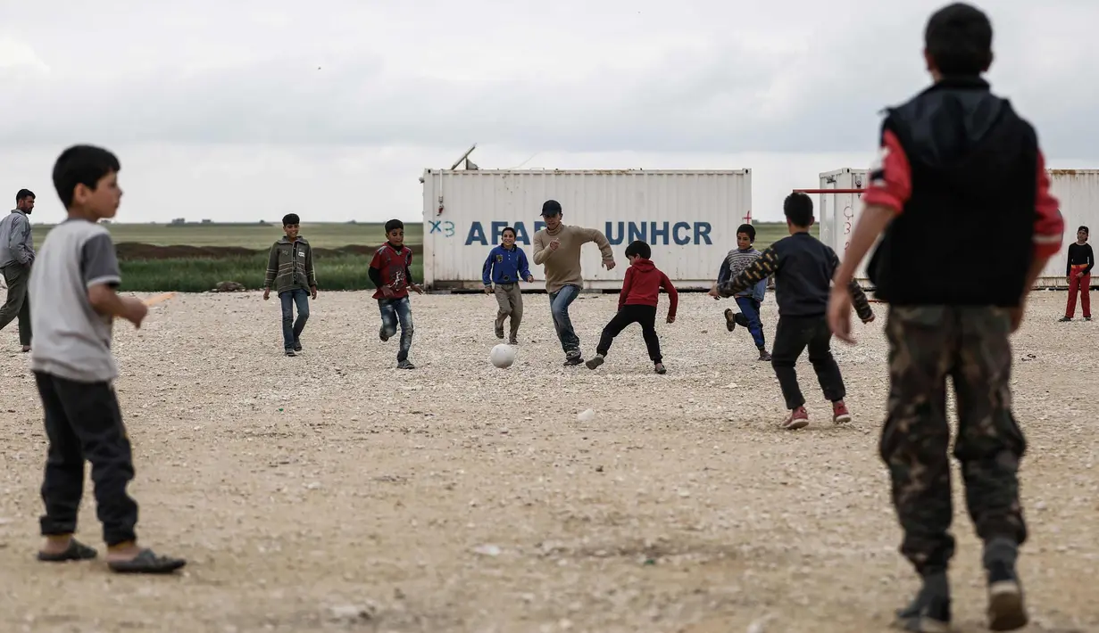 Sejumlah anak pengungsi Suriah bermain sepak bola di sebuah kamp di al-Bil, timur dari kota Azas yang dikuasai pemberontak di Suriah utara (21/4). (AFP Photo/Sameer Al-Doumy)