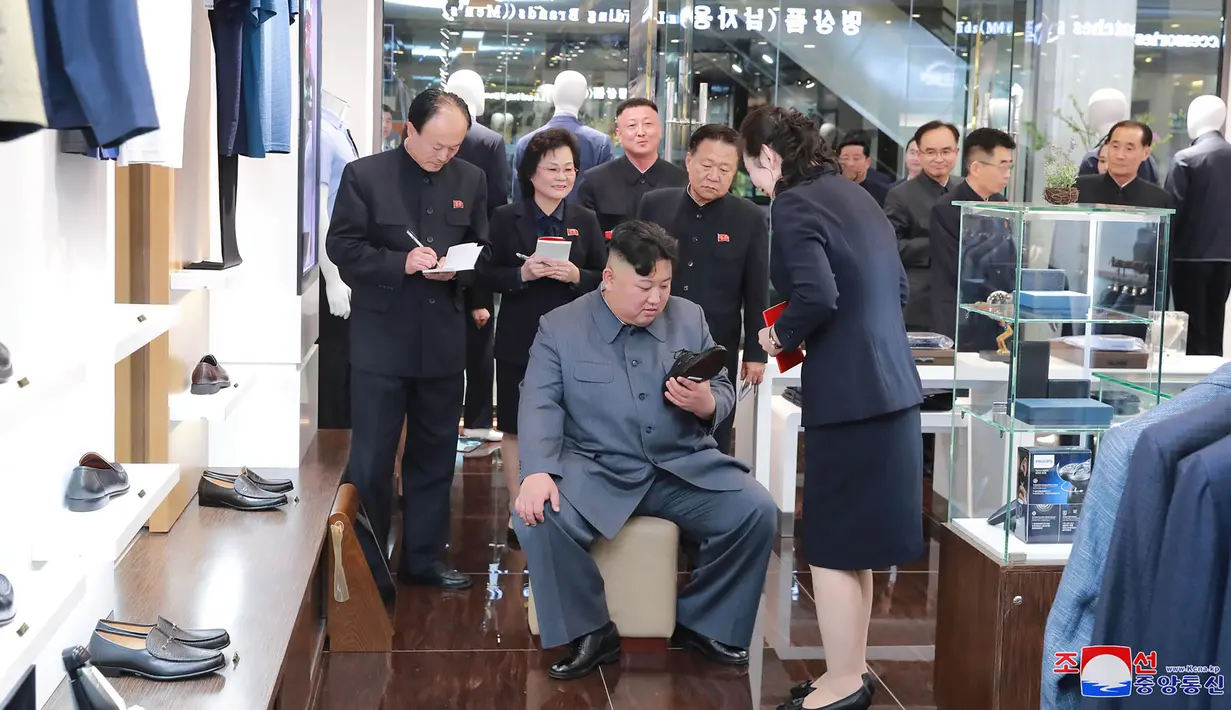 Pemimpin Korea Utara, Kim Jong-un melihat sepatu saat mengunjungi Taesong Department Store, setelah dibuka untuk umum di Korea Utara (8/4). (KCNA VIA AFP Photo)