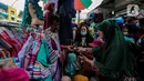 Pengunjung membeli busana muslim yang dijual di Pasar Tanah Abang, Jakarta Pusat, Minggu (2/5/2021). Pusat Grosir Pasar Tanah Abang ramai didatangi pengunjung yang berbelanja menjelang Lebaran dengan berdesak-desakan tanpa jaga jarak. (Liputan6.com/Johan Tallo)
