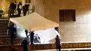 Sejumlah kepolisian menutupi tubuh korban setelah insiden penembakan di sebuah masjid di kota Zurich, Swiss, Senin (19/12). Pelaku yang diperkirakan seorang pria berusia 30 tahun, diyakini telah melarikan diri. (REUTERS/Arnd Wiegmann)