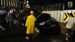 Petugas mengevakuasi mobil pajero yang menabrak pagar pembatas pembangunan proyek  stasiun Mass Rapid Transit (MRT) di belakang Polda Metro Jaya, Jakarta, Jumat (25/1). Tidak ada korban jiwa dalam kecelakaan tunggal tersebut. (Merdeka.com/Dwi Narwoko)