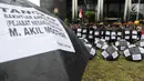 Sejumlah aktivis dari Gema Tapteng berbaris sambil menjejerkan payung hitam saat melakukan aksi unjuk rasa di depan gedung KPK, Jakarta, Kamis (26/4). (Merdeka.com/Dwi Narwoko)