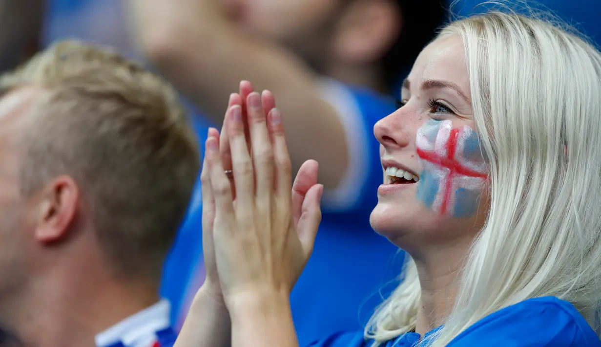 Suporter cantik timnas Islandia bertepuk tangan saat memberi semangat timnas Islandia saat melawan timnas Perancis dalam Perempat Final Piala Eropa 2016 di Stade de France, Prancis, (3/7).  (Reuters/John Sibley)