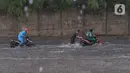 Pengendara terjebak banjir yang menggenangi jalan Bayangkara Pusdiklat, Kota Tangerang Selatan, Banten, Selasa (2/11/2021). BMKG mengeluarkan peringatan potensi cuaca ekstrem di wilayah Jakarta, Bogor, Depok, Tangerang, dan Bekasi (Jabodetabek). (Liputan6.com/Angga Yuniar)