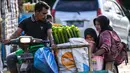 Para peserta mengangkut tabung bambu yang dilapisi daun pisang yang digunakan untuk memasak lemang, hidangan nasi ketan tradisional yang dimasukkan ke dalam tabung bambu dan diisi dengan santan yang kemudian diletakkan di atas api, selama acara memasak massal di Blang Pidie, Kabupaten Aceh Barat Daya, Aceh, pada Sabtu 25 April 2026. (CHAIDEER MAHYUDDIN/AFP)