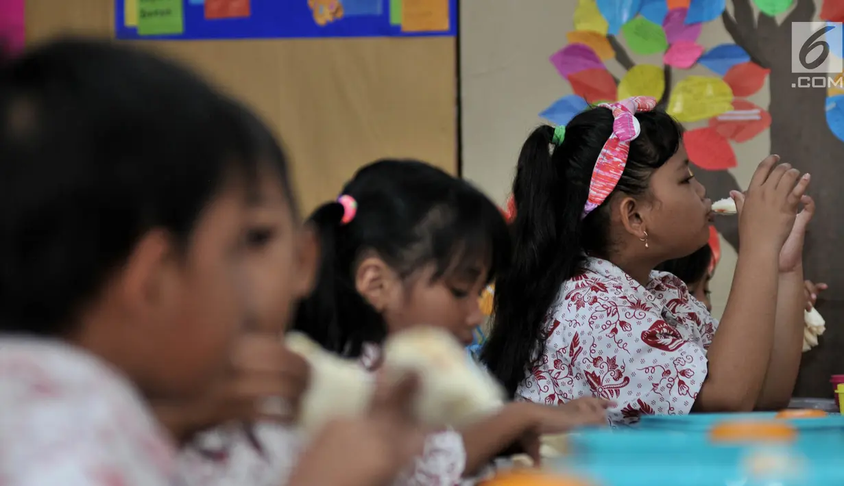 Siswi menyantap makanan tambahan saat program Penyediaan Makanan Tambahan Anak Sekolah (PMTAS) di SD Negeri 01 Tanjung Priok, Jakarta, Kamis (28/3). Pemprov DKI Jakarta menggelontorkan dana Rp 324 miliar untuk memenuhi gizi anak SDN di Jakarta dengan program PMTAS. (merdeka.com/Iqbal S. Nugroho)