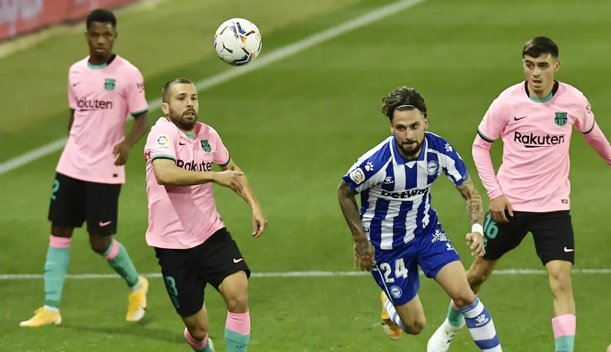 Bek Barcelona, Jordi Alba, berebut bola dengan pemain Alaves, Jose Peleteiro, pada laga Liga Spanyol di Stadion Mendizorroza, Minggu (1/11/2020). Kedua tim bermain imbang 1-1. (AP Photo/Alvaro Barrientos)
