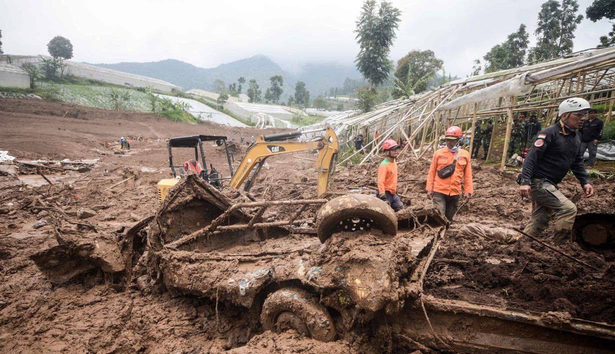 Dari laporan sementara terdapat 30 rumah yang tertimbun material longsor. Hingga kini, petugas pun masih melakukan pencarian terhadap korban yang tertimbun. Tampak dalam foto, tim penyelamat mencari korban yang terkubur longsor di Desa Pasirlangu, Bandung, Jawa Barat, pada Senin 26 Januari 2026. (Timur Matahari/AFP)