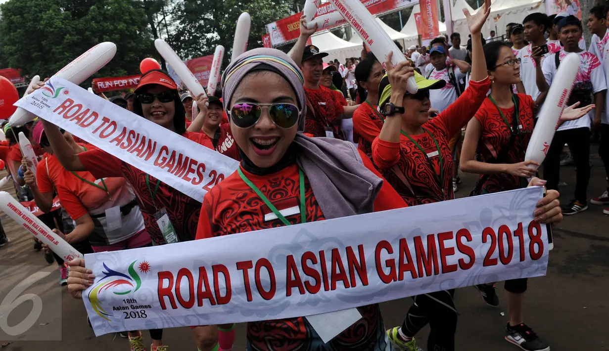 Peserta Parade Asean Games 2018 Jakarta - Palembang membawa baner bertuliskan "Road To Asian Games 2018, Jakarta, Minggu (27/12/2015). Indonesia akan menjadi tuan rumah perhelatan Asian Games 2018 mendatang. (Liputan6.com/Johan Tallo)