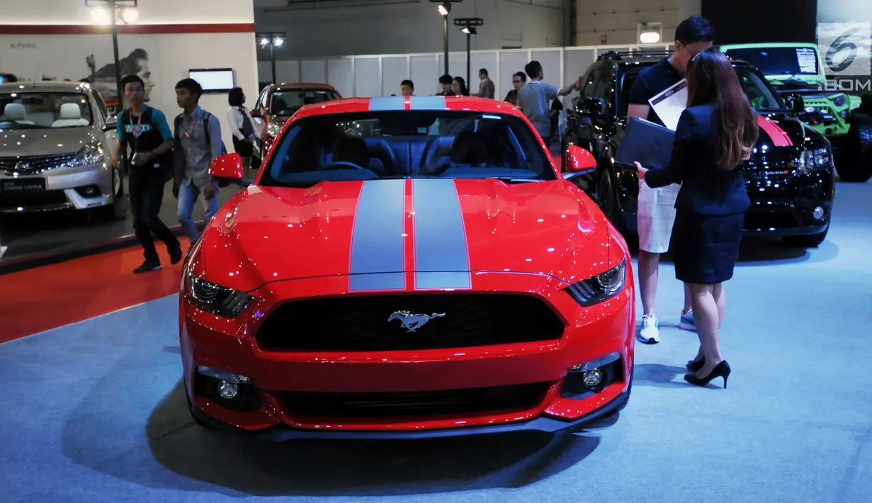 Pengunjung melintas di sisi mobil yang dipamerkan pada Indonesia International Motor Show 2018 di JIExpo, Jakarta, Kamis (19/4). IIMS 2018 diselenggarakan hingga 29 April mendatang. (Liputan6.com/Helmi Fithriansyah)