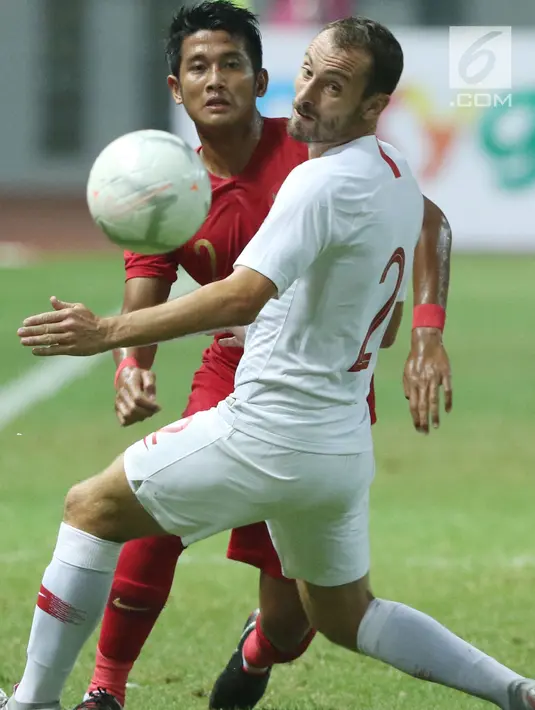 Bek Timnas Indonesia, Putu Gede Juni Antara (kiri) berebut bola dengan pemain Hong Kong, Daniel C Rodriguez pada laga uji coba internasional di Stadion Wibawa Mukti, Cikarang, Selasa (16/10). Laga berakhir imbang 1-1. (Liputan6.com/Helmi Fithriansyah)