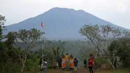 Sejumlah warga mengamati kondisi Gunung Agung, kawasan Karangasem, Bali, Sabtu (2/12). Hingga hari ini, penampakan asap dari kawah Gunung Agung semakin berkurang dibanding beberapa hari lalu. (Liputan6.com/Immanuel Antonius)