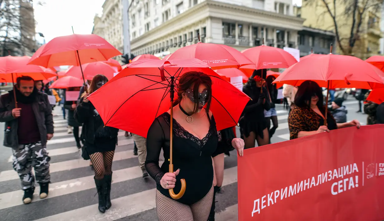 Sejumlah pekerja seks membawa payung merah saat menggelar unjuk rasa di Skopje, Makedonia, Senin (17/12). Mereka menyerukan dihentikannya kekerasan terhadap pekerja seks dan penerapan hukuman bagi pelakunya. (Robert ATANASOVSKI/AFP)