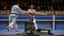 Seorang peserta saat dipukul dengan kayu selama demonstrasi taekwondo sebagai bagian dari Kejuaraan Seni Bela Diri Nasional tahunan Mangyongdae di 'Taekwon-Do Hall' di Pyongyang, Korea Utara (9/11). (AFP Photo/Kim Won Jin)