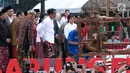 Presiden Joko Widodo melihat proses penenunan kain di Festival Sarung Indonesia 2019, Plaza Tenggara Kompleks GBK, Jakarta, Minggu (3/3). Festival ini untuk menghidupkan kesadaran generasi muda akan kekayaan budaya. (Liputan6.com/Helmi Fithriansyah)