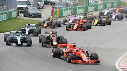 Pembalap Ferrari, Sebastian Vettel memimpin balapan di awal Formula1 Grand Prix (GP) di Montreal, Kanada, Minggu (10/6). Kemenangan Vettel mengambil alih puncak klasemen sementara dari tangan Lewis Hamilton. (Tom Boland/The Canadian Press via AP)