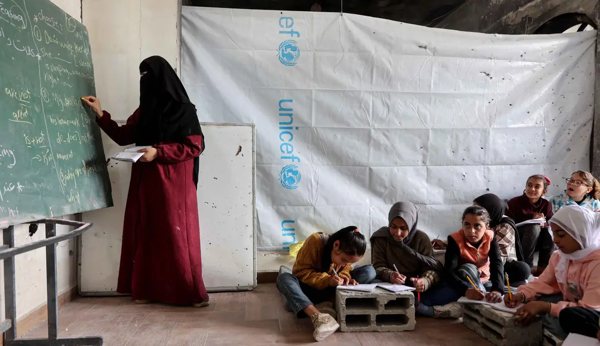 Sekolah Mada merupakan inisiatif untuk memberikan dukungan psikososial dan pendidikan dasar agar anak-anak tidak kehilangan tahun ajaran mereka secara berturut-turut. Tampak dalam foto, anak-anak pengungsi Palestina mengikuti belajar mengajar di dalam tenda di Sekolah Mada, kamp pengungsi Jabalia, Jalur Gaza Utara pada 13 April 2026. (Omar AL-QATTAA/AFP)