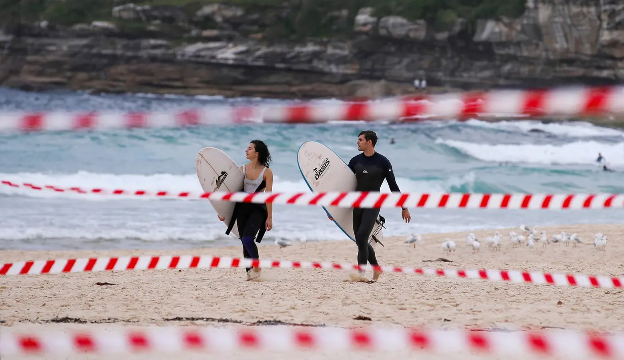 Sejumlah peselancar berjalan di Pantai Bondi di Sydney, Australia (28/4/2020). Industri pariwisata Australia mengalami kerugian sekitar 5,8 miliar dolar Australia (1 dolar Australia = Rp10.579) dalam tiga bulan pertama 2020 seiring merebaknya pandemi coronavirus. (Xinhua/Bai Xuefei)
